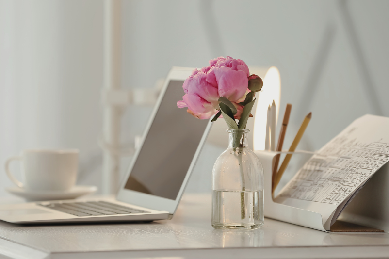 women's desk with laptop and pink flower